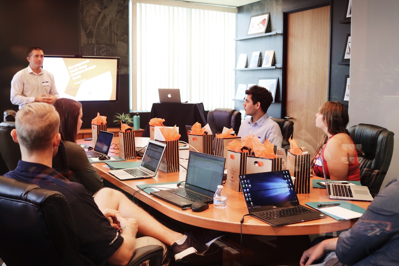 Sesión de capacitación empresarial con presentador y equipo con laptops